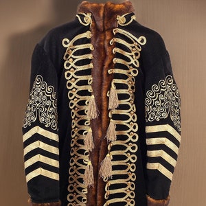 May include: A black velvet jacket with gold braid trim and a fur collar. The jacket has a long, fitted silhouette and features a decorative pattern on the sleeves.