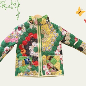 Puede incluir: Una chaqueta acolchada verde con un diseño de patchwork que presenta varios colores y patrones, incluyendo rojo, amarillo, rosa y azul.