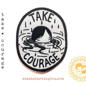 May include: Embroidered iron-on patch with the words "TAKE COURAGE" in a black and white design. The patch features a person submerged in water. The patch also includes the text "stasiaburrington.com".