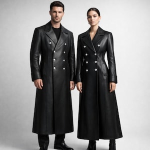 May include: Two long black leather coats featuring double-breasted fronts with silver-toned buttons, wide notched lapels, and structured tailoring. Each coat extends to the lower calf and includes long sleeves with cuffs, providing a uniform appearance.