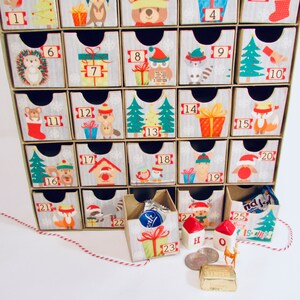 Woodland wonder animals decorate this unique handmade heirloom quality advent calendar.  A reusable year-after-year countdown to Christmas set of mini drawers will be a favorite decoration for years to come.