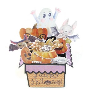 May include: A pop-up card with a Halloween theme. The card features a basket filled with pumpkins, candy corn, and other Halloween treats. There are also several Halloween characters, including a ghost, a bat, and a spider. The card says "Happy Halloween" on the front.