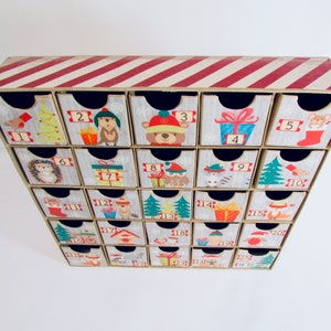 Woodland wonder animals decorate this unique handmade heirloom quality advent calendar.  A reusable year-after-year countdown to Christmas set of mini drawers will be a favorite decoration for years to come.