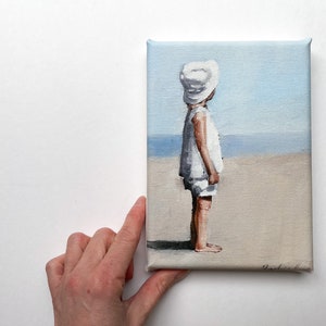 little dreamer: child wearing white sunhat looking out across beach, mini canvas art print