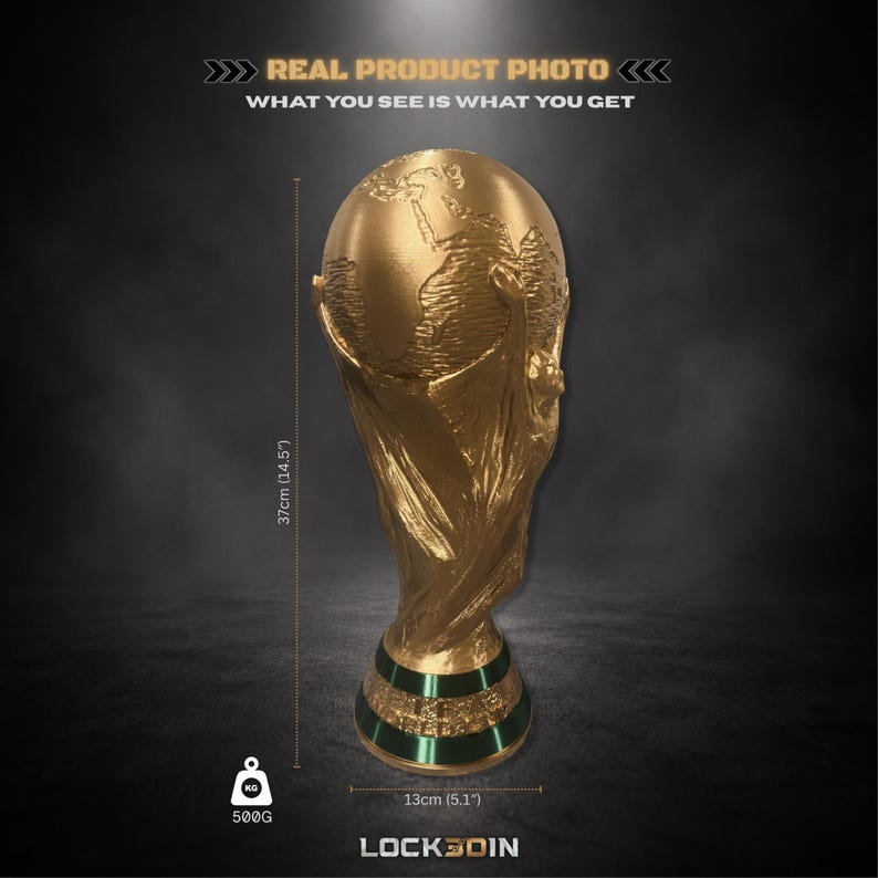 Peut inclure: Un troph&eacute;e de couleur dor&eacute;e repr&eacute;sentant un globe soutenu par deux figures, avec une bande verte &agrave; la base. Le texte indique : REAL PRODUCT PHOTO, WHAT YOU SEE IS WHAT YOU GET, 37cm (14.5"), 500G, 13cm (5.1"), et LOCK3DIN.