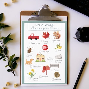 May include: A clipboard with a printed "On a Walk Scavenger Hunt" checklist. The checklist includes illustrations of a red truck, maple leaf, squirrel, stop sign, bug, yellow house, puppy dog, yellow flower, mailbox, fence, and pinecone.