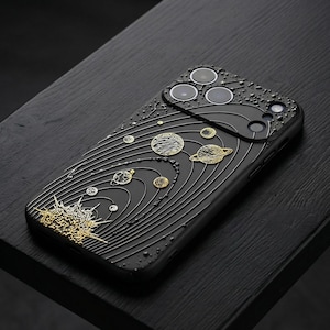Peut inclure: Coque de t&eacute;l&eacute;phone noire avec un motif d&eacute;taill&eacute; du syst&egrave;me solaire en or et argent. La coque pr&eacute;sente une surface textur&eacute;e avec des plan&egrave;tes et des trajectoires orbitales en relief. Le design comprend un &eacute;clat solaire en bas.