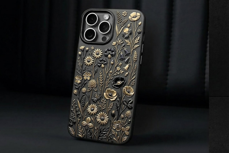 May include: Black smartphone case with a gold and black floral pattern. The case has an embossed design of various flowers, leaves, and stems, giving a textured, 3D appearance. The case is designed for a smartphone.