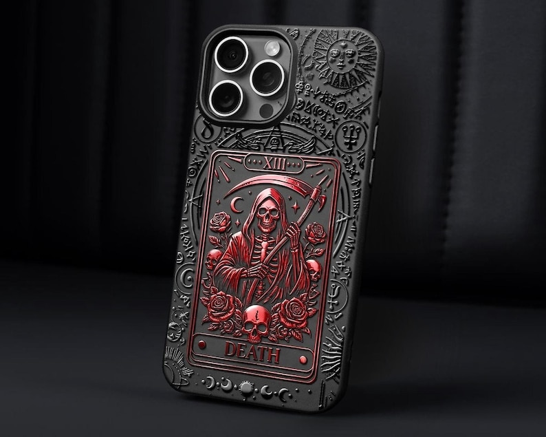 K&ouml;nnte beinhalten: Schwarze Handyh&uuml;lle mit einem rot-schwarzen gepr&auml;gten Design, das eine Tarotkarte des Sensenmanns zeigt. Die H&uuml;lle hat eine detaillierte, gotische &Auml;sthetik mit Rosen, Totenk&ouml;pfen und dem Wort "DEATH".