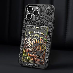K&ouml;nnte beinhalten: Schwarze Handyh&uuml;lle mit detailliertem, gepr&auml;gtem Design. Die H&uuml;lle zeigt den Text "WILL BURN SAGE and bridges AS NEEDED" in Gold und Orange, mit zus&auml;tzlichen Symbolen und einem Sonnendesign. F&uuml;r ein Smartphone.