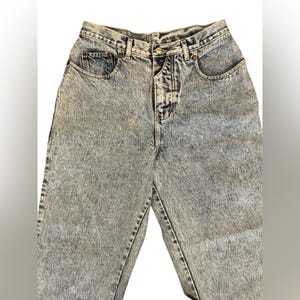 May include: Light blue acid wash denim jeans with a button fly and five pockets.