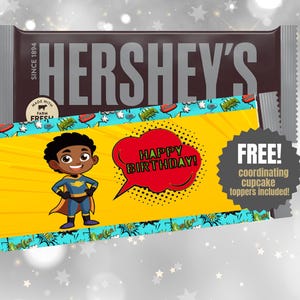 May include: A Hershey's chocolate bar with a custom wrapper featuring a cartoon superhero and the words "HAPPY BIRTHDAY!" in a speech bubble. The wrapper is yellow with a blue and green border.