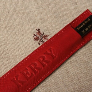 May include: Red leather chopsticks case with the name "Kerry" embossed on the front and the text "Kerry & Dani 25.08.2016" on the inside.