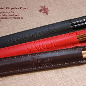 May include: Three leather chopsticks pouches with different logos. The top pouch is black with the word "NOZOMI" embossed in white. The middle pouch is red with the word "VARDE" embossed in white. The bottom pouch is brown with the words "Imperial Tobacco" embossed in white.