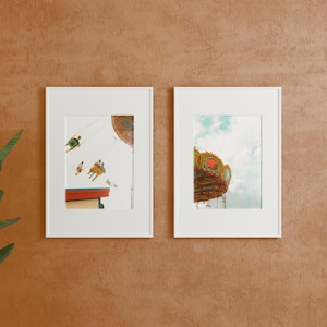 May include: Two framed photographs of a carnival ride. The first photo shows people riding a swing ride against a blue sky. The second photo shows the top of a carousel with colorful horses and a red roof.