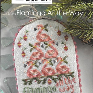 May include: A cross-stitch pattern for a Christmas ornament featuring a pink flamingo Christmas tree with the text "Flamingo All the Way".