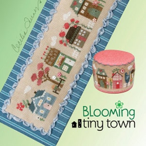 May include: Cross stitch pattern for a sampler featuring a row of colorful houses with flowers and birds. The pattern is titled "Blooming Tiny Town" and is from Heart in Hand Designs.