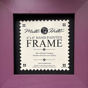 May include: A purple 6x6 inch hand painted wooden picture frame with a black mat and a white label that reads "Mile Hill 6"x 6" HAND PAINTED FRAME Hole drilled for hanging Includes dowel for easel display www.wichelt.com optional: To secure back, use glazier points, available at your local hardware or framing store. ©2010 Mile Hill"