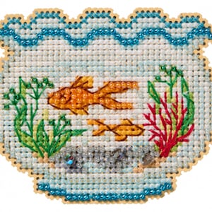 May include: Cross-stitch design of a fishbowl with two orange goldfish, green plants, and red coral. The fishbowl is outlined in a light brown color and has a blue beaded border. The background is a light blue color.