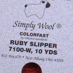 May include: A skein of ruby red Simply Wool yarn, colorfast by industry standards. The label reads "Ruby Slipper 7100-W, 10 YDS".