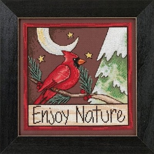May include: A cross-stitch pattern featuring a red cardinal perched on a branch with berries, a crescent moon, and a snowy pine tree. The text "Enjoy Nature" is below the image.