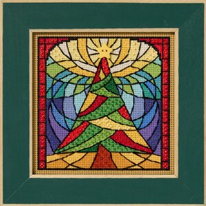 May include: A framed needlepoint artwork featuring a colorful Christmas tree design. The tree is composed of red, green, and yellow sections, set against a stained-glass style background with a star at the top. The artwork is framed in a green wooden frame.