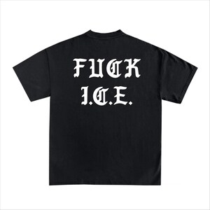 Puede incluir: Camiseta negra con el texto blanco "FUCK I.C.E." en letras g&oacute;ticas. La camiseta tiene cuello redondo y mangas cortas. La tela parece ser una mezcla de algod&oacute;n suave.