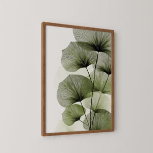 May include: A framed art print featuring stylized green fan-shaped leaves with black stems against a white background. The leaves have a detailed, linear design. The frame is made of brown wood, adding a natural touch to the botanical artwork.
