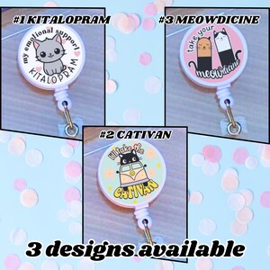May include: Three retractable badge reels with cat-themed designs. One reel features a gray cat and the text "#1 KITALOPRAM my emotional support". Another has a black cat in a van with the text "#2 CATIVAN". The third reel has two cats and the text "#3 MEOWDICINE".
