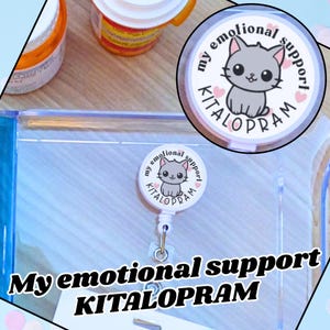 May include: A white badge reel with a cartoon gray cat illustration and the words "my emotional support KITALOPRAM". The badge reel is round and has a retractable cord and a metal clip.