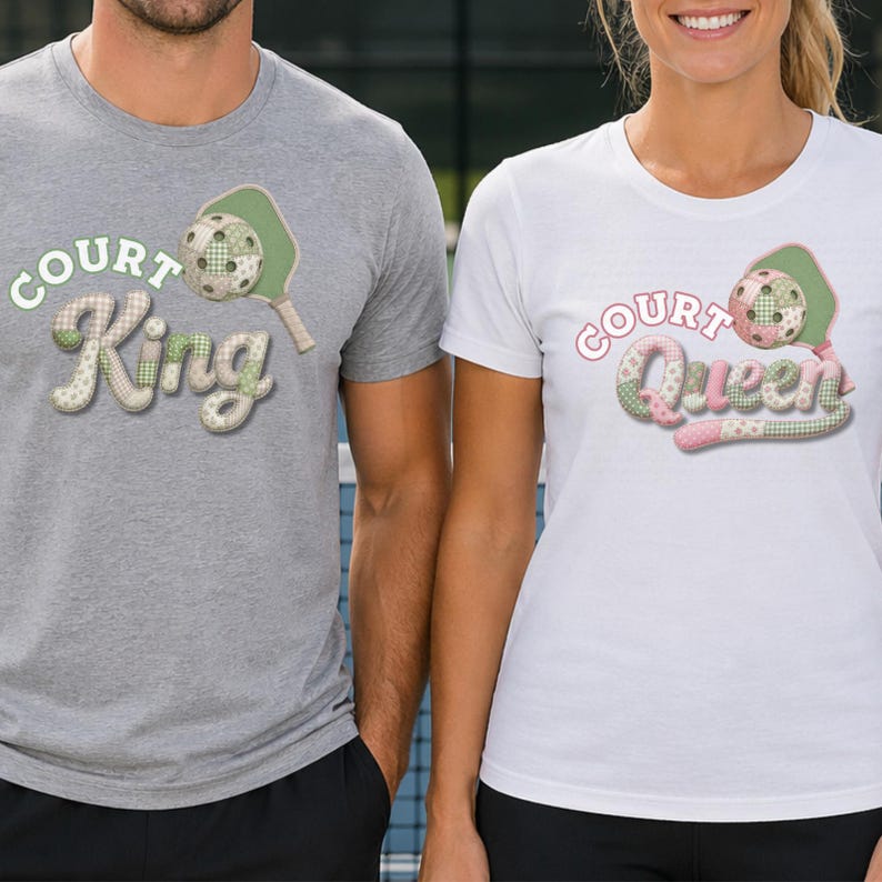 May include: Two t-shirts, one gray and one white, featuring pickleball-themed graphics. The gray shirt says "Court King" with a pickleball and paddle design. The white shirt says "Court Queen" with a similar design. Both shirts have a playful, quilted aesthetic.
