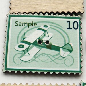 May include: A green and white vintage-style stamp with a green border and a white airplane with a black stripe. The stamp says "Sample" and "10" in the top corners.