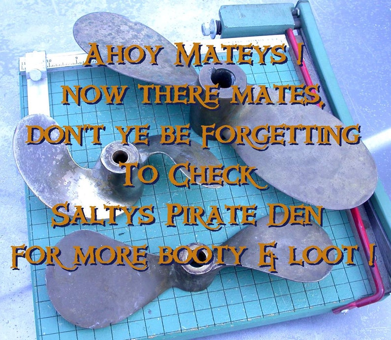 May include: Three bronze boat propellers on a blue and white grid surface. The propellers are arranged in a triangular shape. Text on the image reads: "Ahoy Mateys! Now there mates, don't ye be forgetting to check Salty's Pirate Den for more booty & loot!"