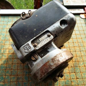 Puede incluir: Magneto Wico Tipo C 150C vintage con parte superior negra y cuerpo plateado. El magneto tiene un aspecto desgastado con óxido visible y el texto "USE LIGHT OIL". El número de serie es 437684.