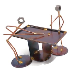May include: A metal sculpture of two figures playing pool. The figures are made of wire and nuts, and the pool table is made of metal. The sculpture is painted in shades of brown and gold.