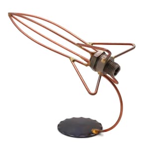 May include: A copper wire sculpture of a rocket ship with a metal base. The rocket ship is made of copper wire and has a metal base. The rocket ship is about 10 inches tall.