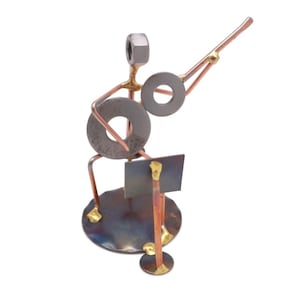 May include: A metal sculpture of a musician playing a guitar. The sculpture is made of various metal pieces, including nuts, bolts, and washers. The musician is sitting on a stool and holding a guitar in their hands. The sculpture is painted in a metallic finish.