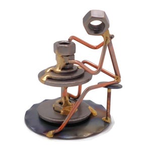 May include: A metal sculpture of a person sitting on a stool and using a pottery wheel. The sculpture is made of nuts, bolts, and wire. The pottery wheel is made of metal washers and a nut. The sculpture is painted in shades of gold, silver, and copper.