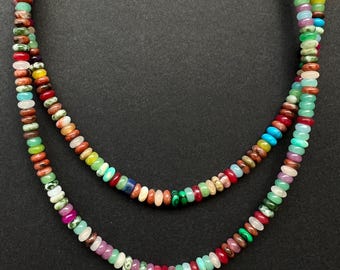 May include: Two strands of colorful gemstone beads, each strand featuring a variety of colors and patterns. The beads are round and smooth, and the strands are arranged in a circle.