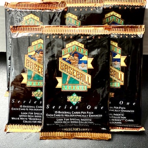 Puede incluir: Varios paquetes sin abrir de cromos de béisbol Upper Deck Serie One de 1993. Los paquetes son negros con detalles dorados y presentan el logotipo de la Major League Baseball. Cada paquete contiene 15 cromos y está mejorado holográficamente.