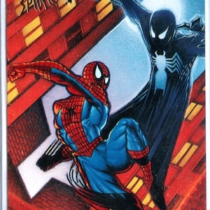 K&ouml;nnte beinhalten: Sammelkarte mit Spider-Man in einem rot-blauen Kost&uuml;m, der gegen einen schwarz gekleideten Spider-Man k&auml;mpft. Die Karte tr&auml;gt den Text "Alien Costume Saga" und "Fleer Ultra Spider-Man". Der Hintergrund zeigt eine Stadtlandschaft.