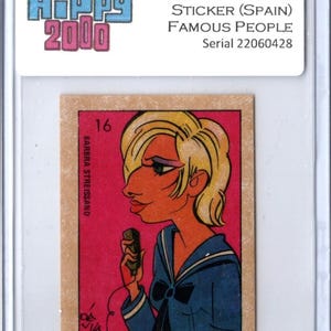 May include: A vintage 1973 "Famous People" sticker from Spain, featuring an illustration of Barbra Streisand. The sticker has a pink background and a cartoon-style image of the singer in a blue sailor-style outfit. The sticker is encased in a protective holder.