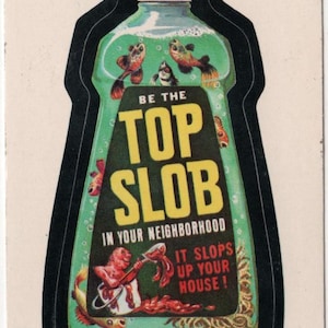 May include: A green and yellow bottle with the words "Be the Top Slob in your neighborhood" and "It Slops Up Your House!" printed on it. The bottle is filled with green liquid and has several goldfish swimming inside. The bottle is surrounded by a black border.