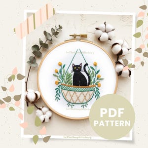 May include: Black cat embroidery pattern in a hoop with green leaves and yellow flowers. The pattern is titled "In The Hoop Stitchery" and says "PDF Pattern".