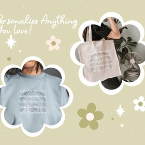 May include: A light blue sweatshirt with a black line drawing of a nativity scene with the text "Gather 'round the manger" above and below the image. The sweatshirt is displayed on a model.