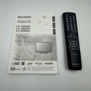 May include: A Sharp Aquos TV operation manual and remote control. The manual includes the model numbers LC-42D65U, LC-46D65U, and LC-52D65U. The remote is black with multiple buttons and the Sharp and Aquos logos.