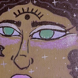 May include: A close-up of a painting of a person's face. The person has green eyes, a brown nose, and a third eye on their forehead. The background is a brown canvas with white stars.