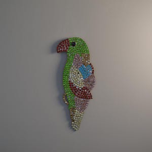 Peut inclure: Une décoration de perroquet en strass vert, rose et bleu. Le perroquet est fait de strass et est une pièce décorative.