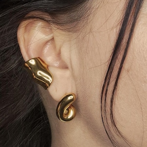 Peut inclure: Une tasse en céramique blanche avec une anse noire et le texte "But First, Coffee" en noir, dans une police manuscrite. La tasse est posée sur une surface blanche.