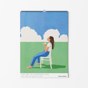 May include: A wall calendar featuring an illustration of a person in a white shirt and blue pants sitting on a white chair in a green field under a blue sky with white clouds. The text reads THE ART OF EVERYDAY LIFE FOR A BETTER WORLD IN 2027 GISELLE DEKEL.
